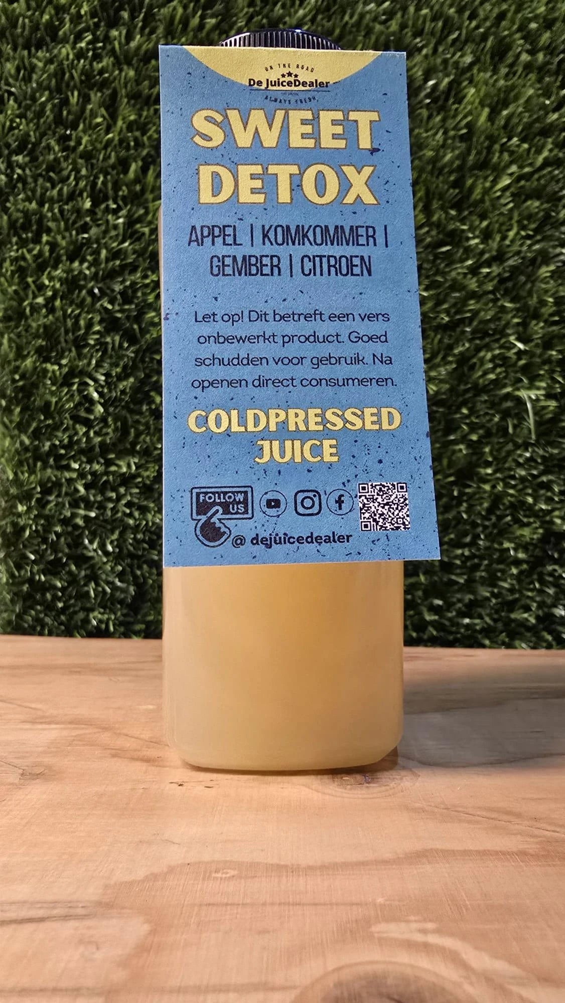 "Sweet Detox cold-pressed juice fles met label van De JuiceDealer, met ingrediΓ«nten appel, komkommer, gember en citroen."