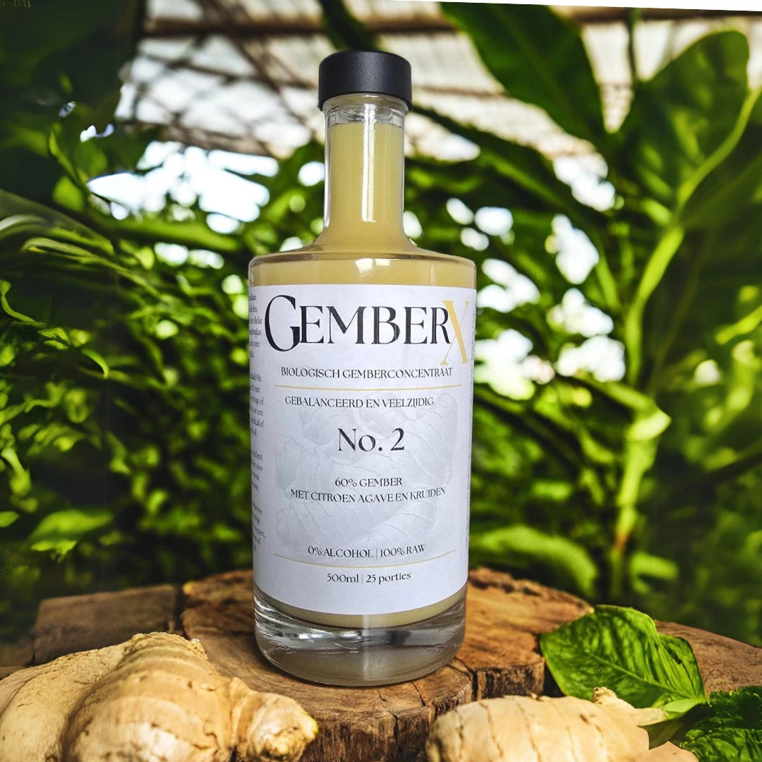 GemberX No.2 - Biologisch gemberconcentraat met 60% gember, citroen, agave en kruiden, gepresenteerd op een houten plank met groene bladeren op de achtergrond.